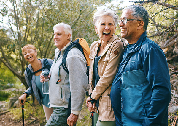 A group of four middle aged men and women walking and smiling.