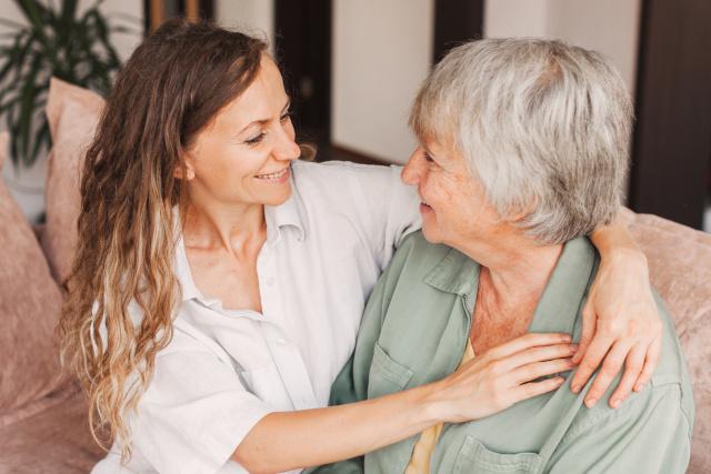 A young woman hugging an older woman