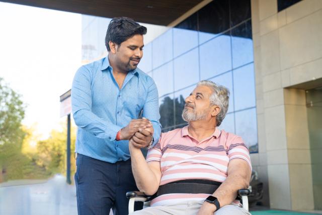 Carer helping a man in a wheelchair