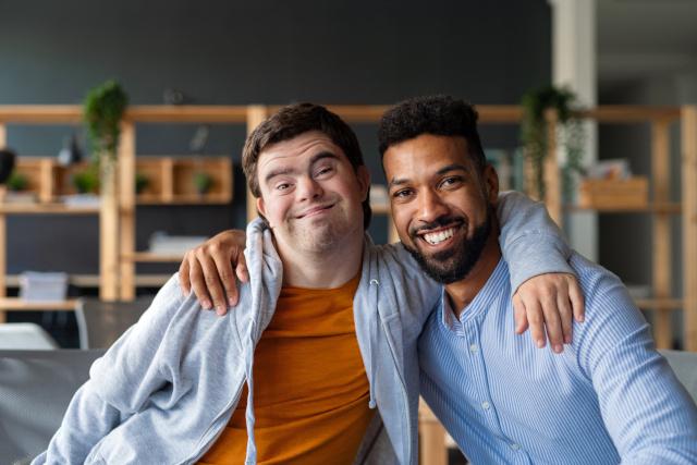 Two men with their hands over each others shoulders