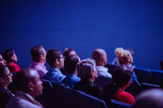 A group of people sat in a dark cinema