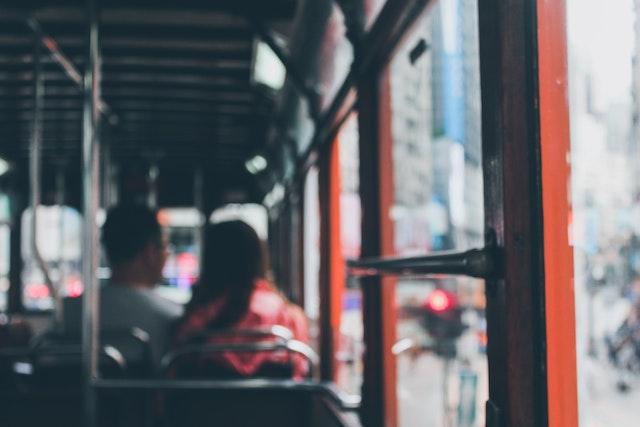 The interior of a bus with a man and woman sat facing away